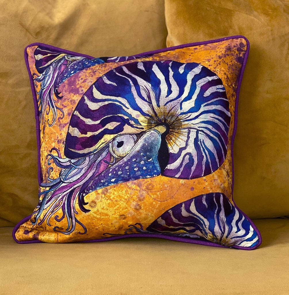 purple nautilus on an orange background cotton cushion with purple piping
