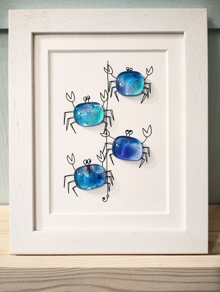 framed picture of fused glass crabs on a crab line by Niko Brown