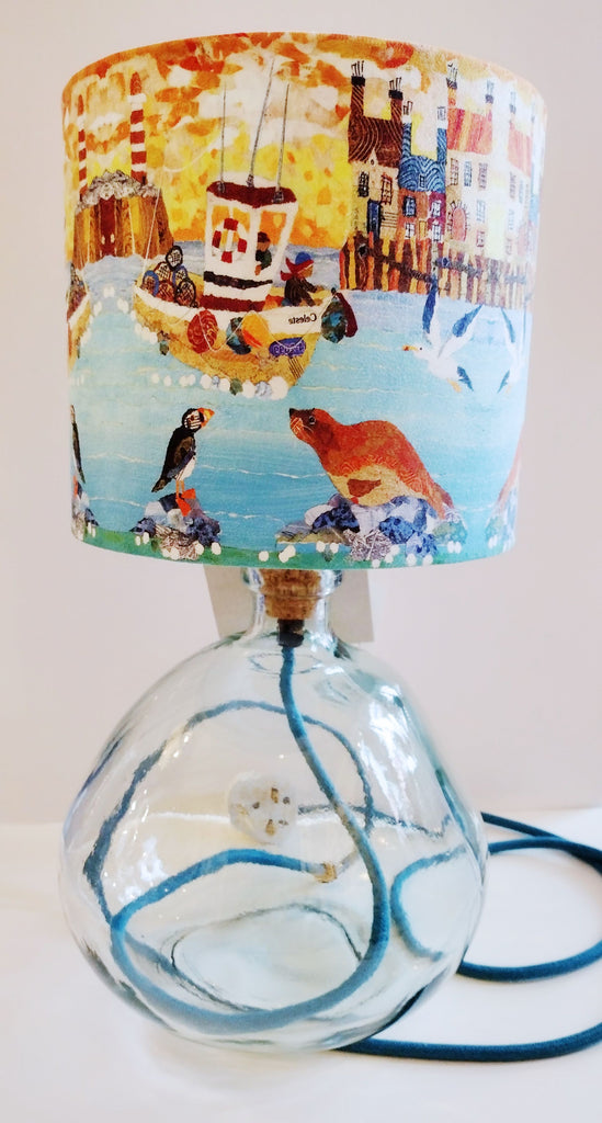 Pale grey recycled glass lamp-base shown with a coastal themed lampshade